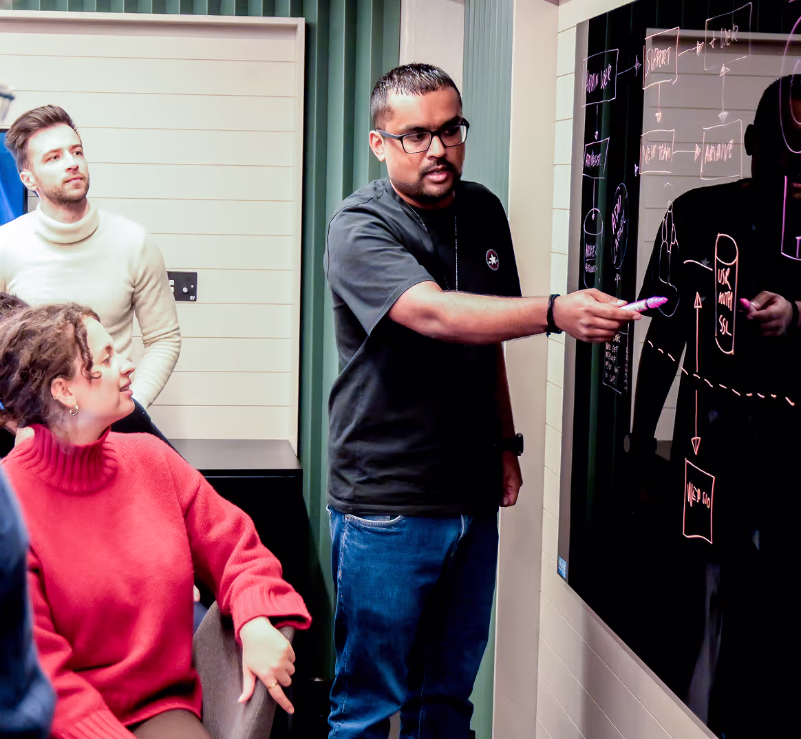 A team member sketching the platform architecture on a whiteboard